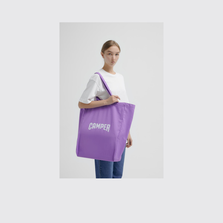 A model wearing Totes Purple Tote Unisex Shoulder Bag