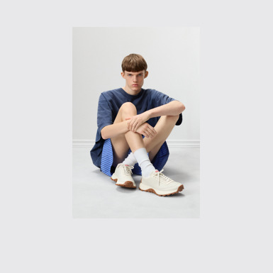 A model wearing Drift Trail White Leather Sneakers for Men.