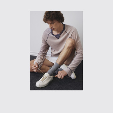 A model wearing Pelotas White Leather Men's Shoes.