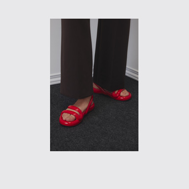 A model wearing Kobarah Flat Red Sandals.