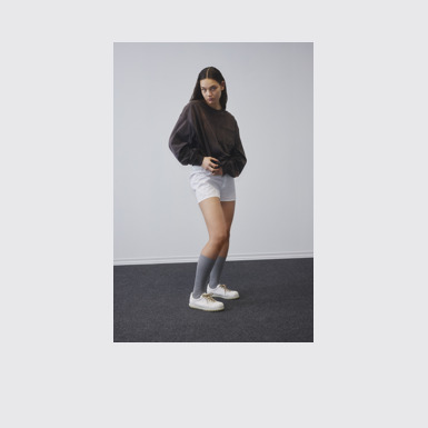 A model wearing Pelotas White Leather Shoe for Women.