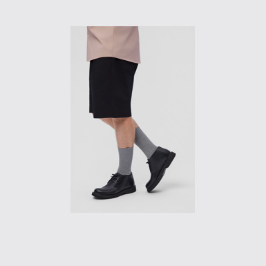 A model wearing Norman Black Leather Ankle Boots for Men.