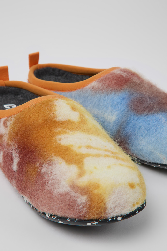 Close-up view of Wabi Orange, blue, and white recycled wool slippers for women
