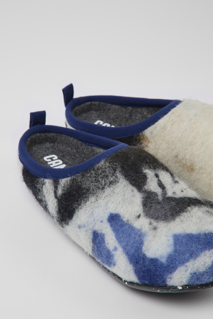 Close-up view of Wabi Blue, black, and white recycled wool slippers for women