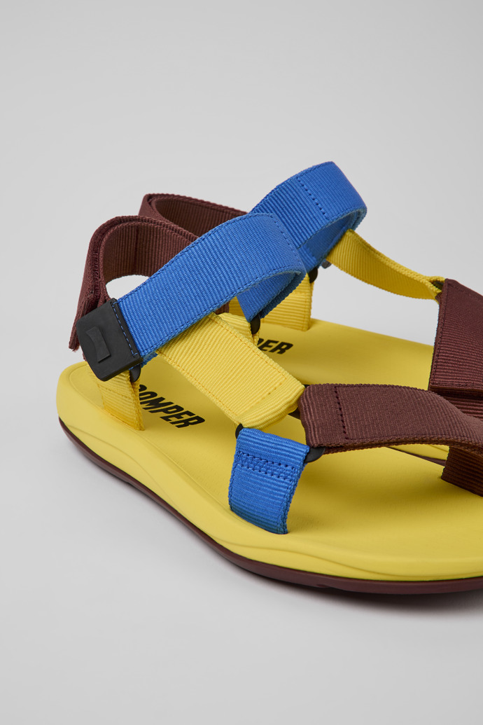 Close-up view of Match Yellow, blue, and burgundy sandals for men