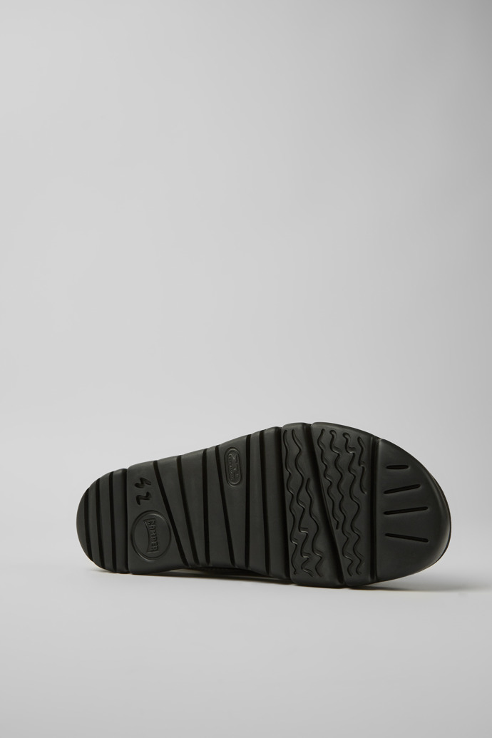The soles of Oruga Grey, black, and green sandals for men