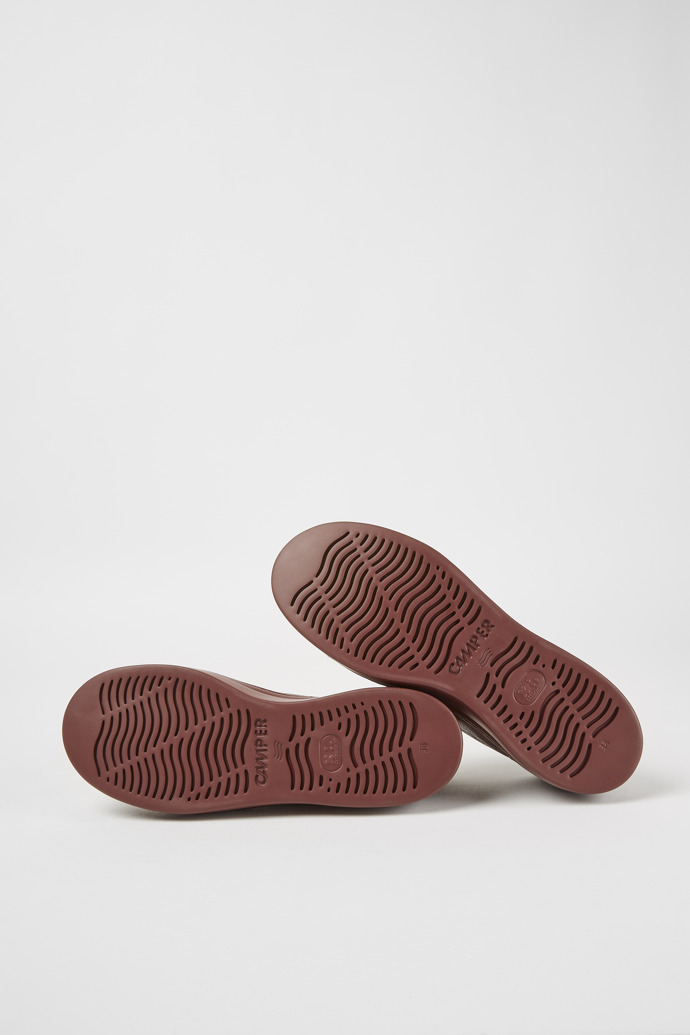 The soles of Runner Up Burgundy leather sneakers