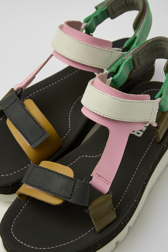 Close-up view of Oruga Up Green, pink, and white leather sandals for women