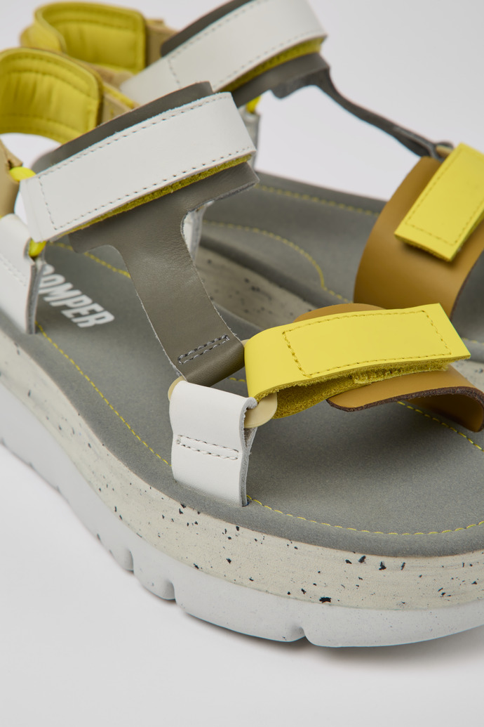 Close-up view of Oruga Up White, grey, and yellow leather sandals for women