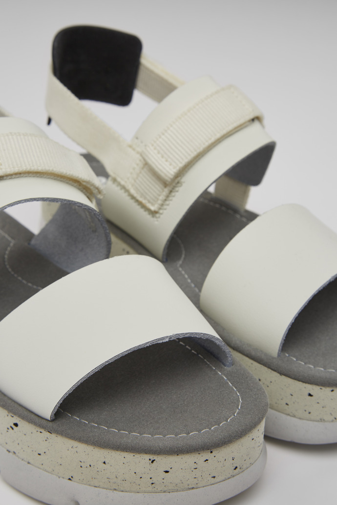 Close-up view of Oruga Up White and black leather sandals for women