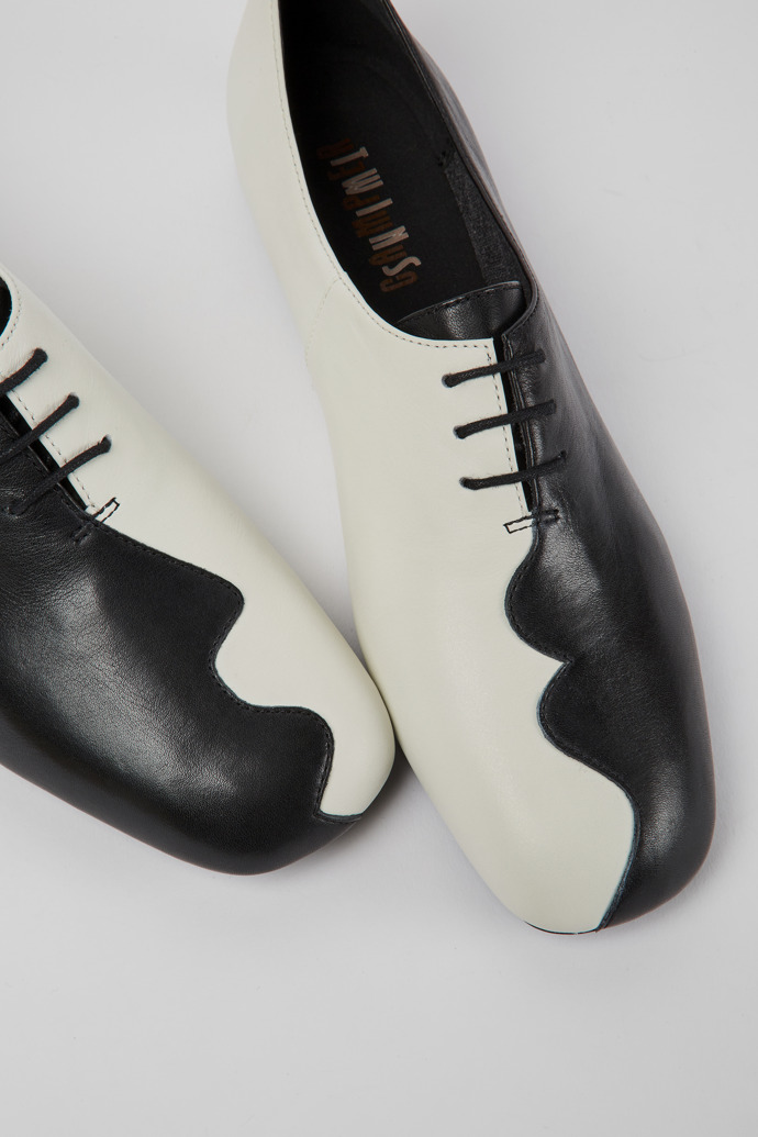 Close-up view of Twins Black and white leather shoes