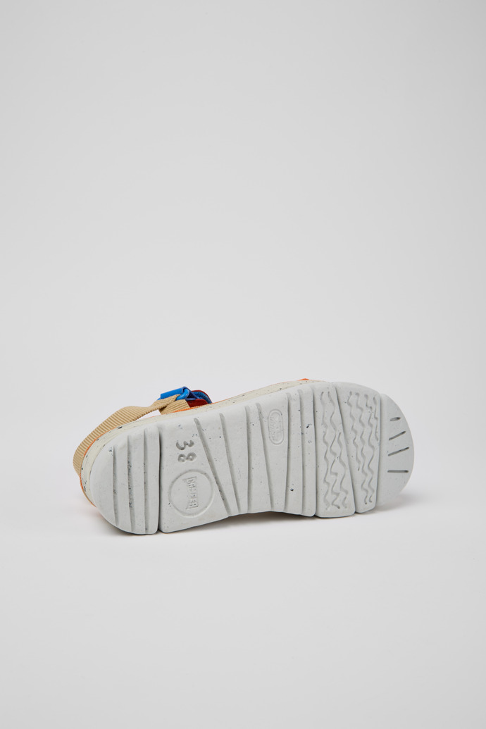 The soles of Oruga Up Beige, blue, and red sandals for women