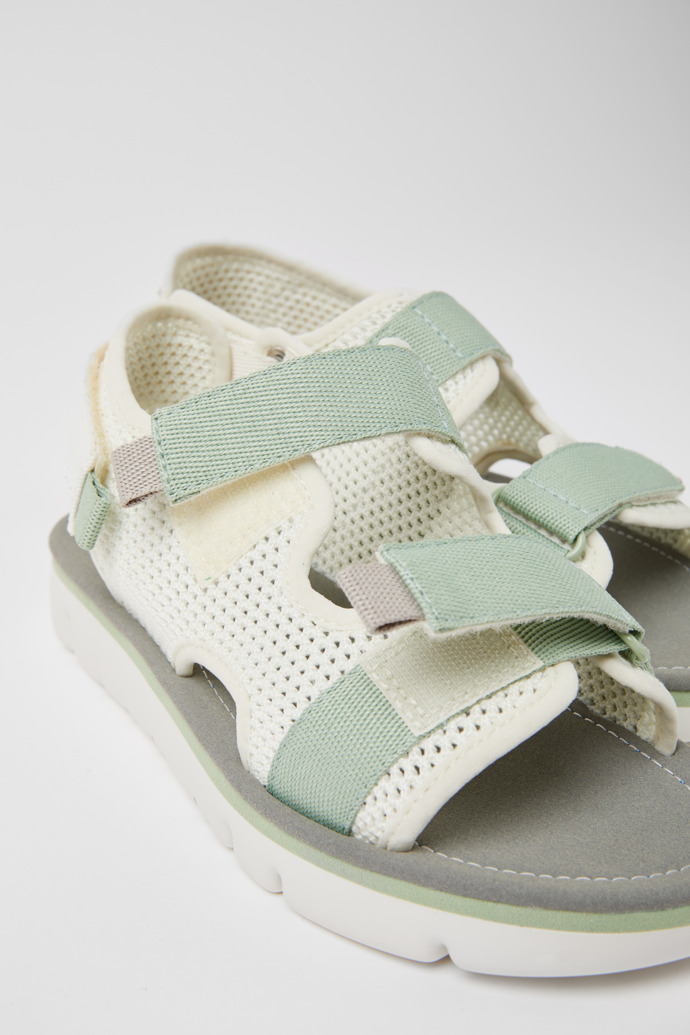 Close-up view of Oruga White, green, and grey sandals for women