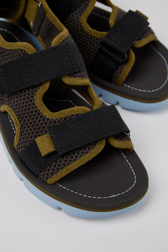 Close-up view of Oruga Grey, green, and black sandals for women