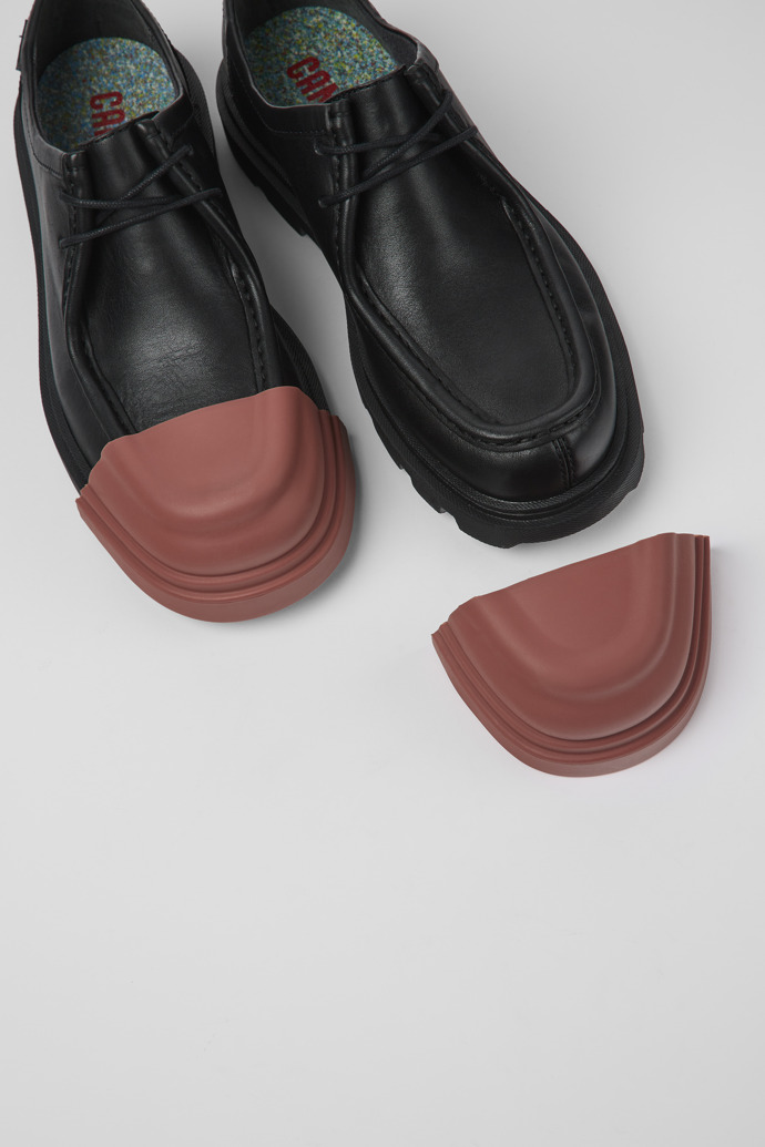 A model wearing Junction Black Leather Wallabee Shoe for Women