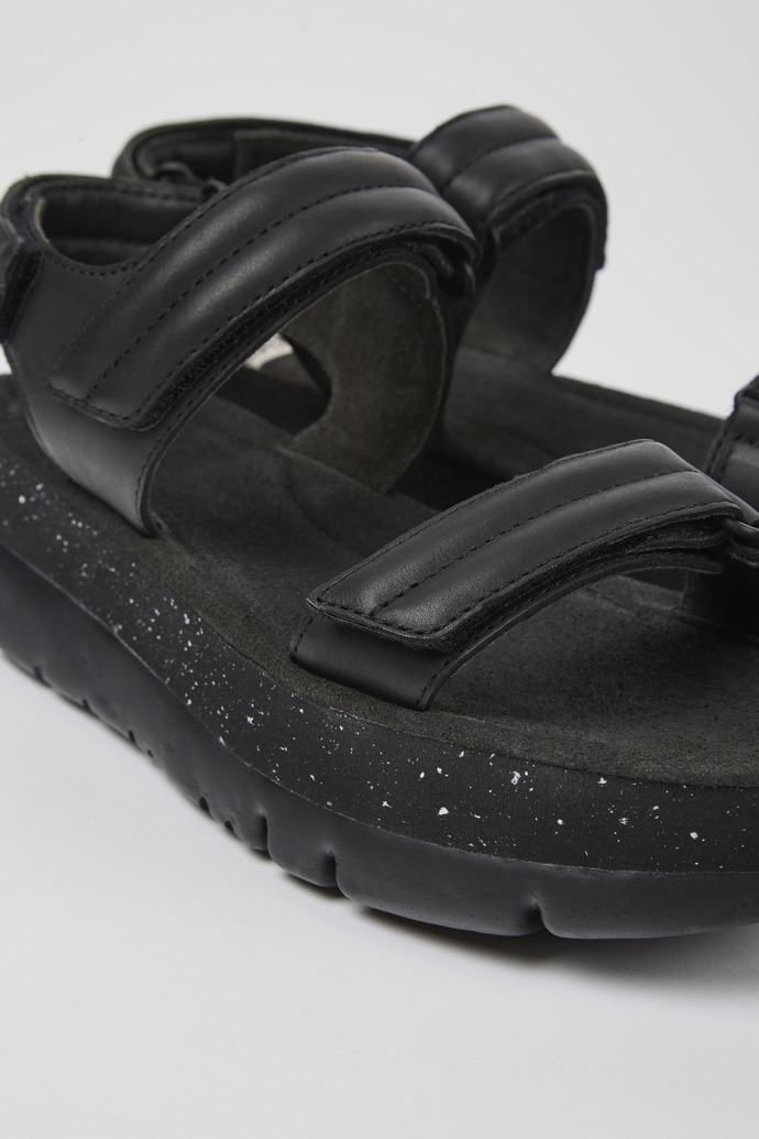 Close-up view of Oruga Up Black leather sandals for women
