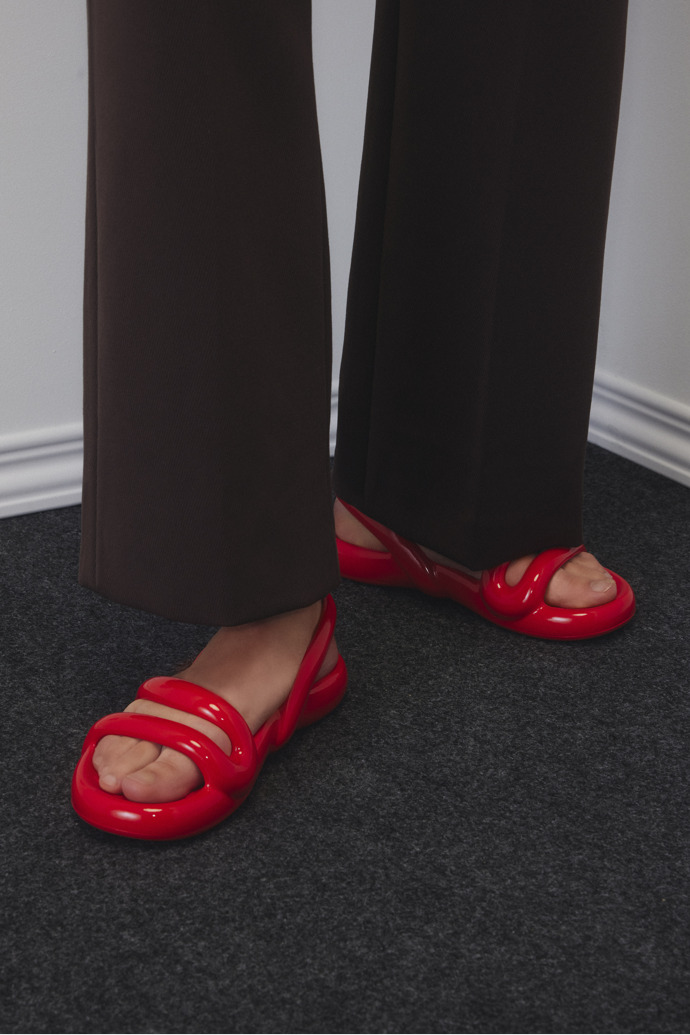 A model wearing Kobarah Flat Red Women's Sandals.