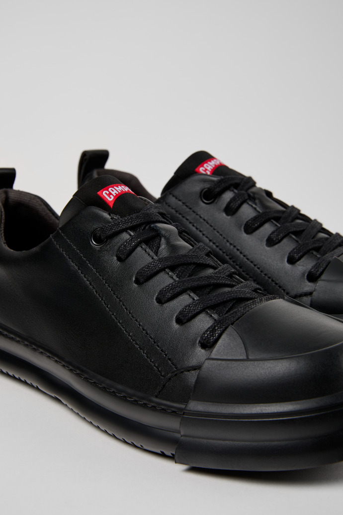 Close-up view of Junction Runner Black Leather Sneakers for Women.