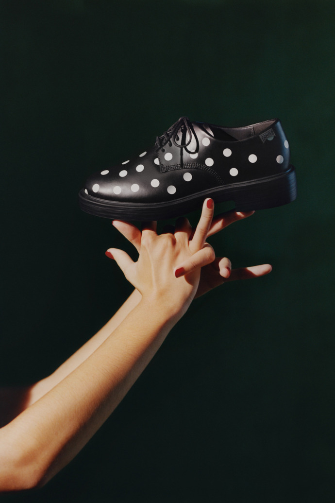 A model wearing Dean Black and White Leather Shoes for Women.