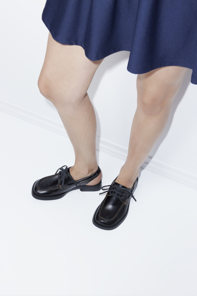 A model wearing Donna Black Leather Semi-Open Shoes for Women.