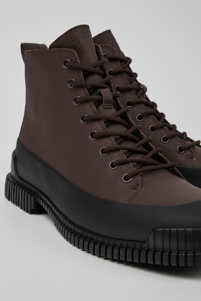 Close-up view of Pix Brown and black leather lace-up boots for men