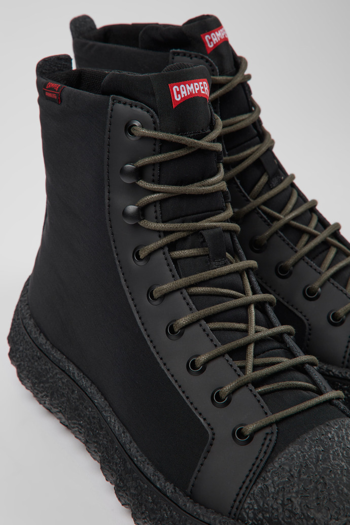 Close-up view of Ground PrimaLoft® Black textile and leather ankle boots for men