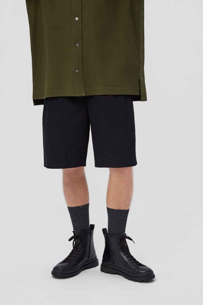 A model wearing Brutus+ Black Leather Mid Boots for Men.