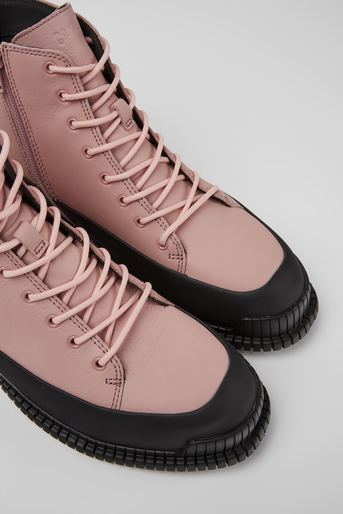 Close-up view of Pix Pink and black leather lace-up boots for women