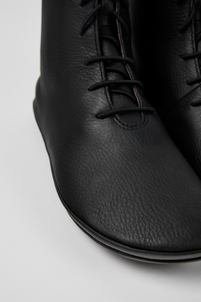Close-up view of Right Black leather ankle boots