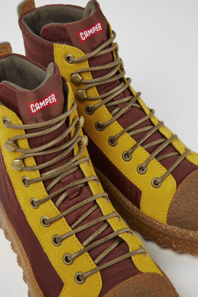 Close-up view of Ground Burgundy and yellow ankle boots
