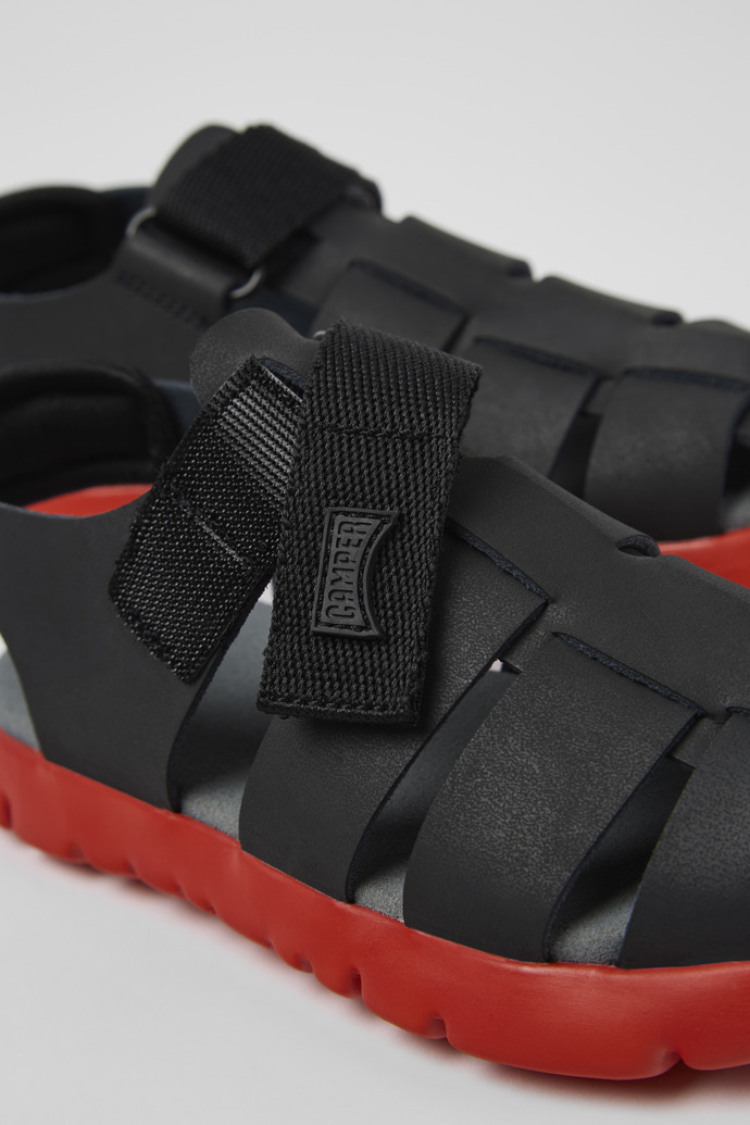 Close-up view of Oruga Black Leather/Textile Sandal