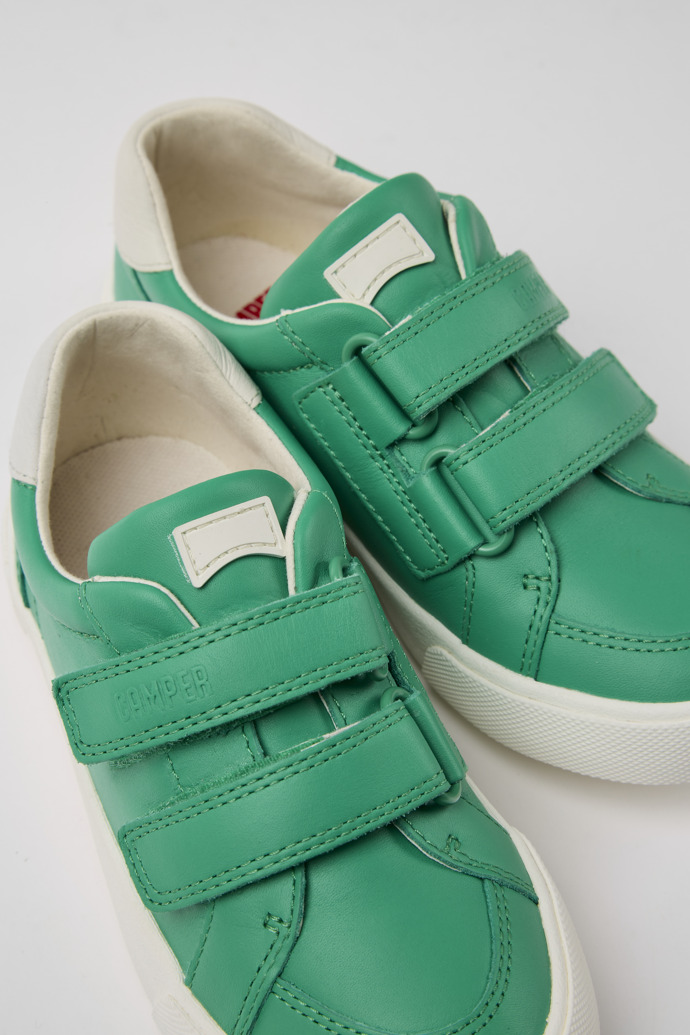 Close-up view of Pursuit Green and white sneakers for kids