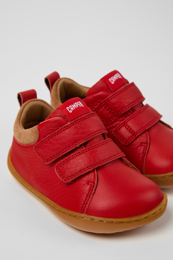 Peu Baskets en cuir et nubuck rouges et marron pour enfants.