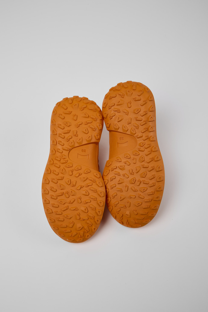 The soles of CRCLR White and orange sneakers for kids