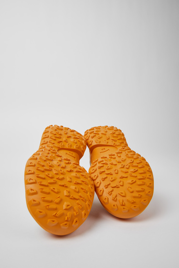 The soles of CRCLR White and orange sneakers for kids