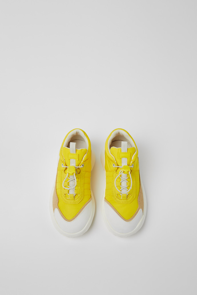 Overhead view of CRCLR Yellow, beige, and white sneakers for kids