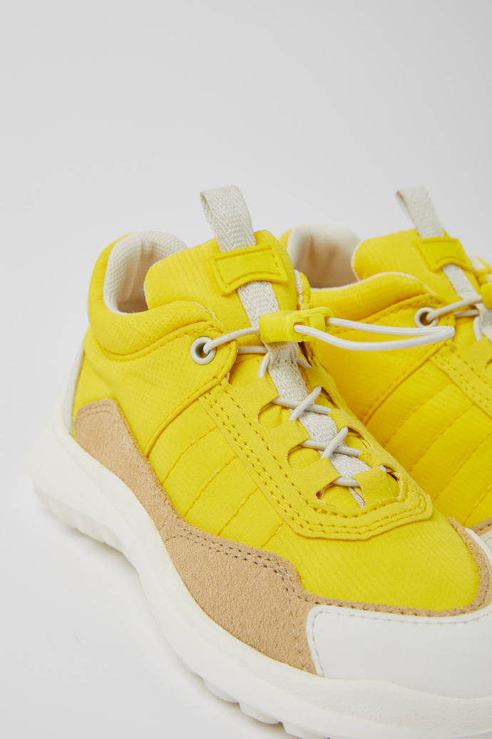 Close-up view of CRCLR Yellow, beige, and white sneakers for kids