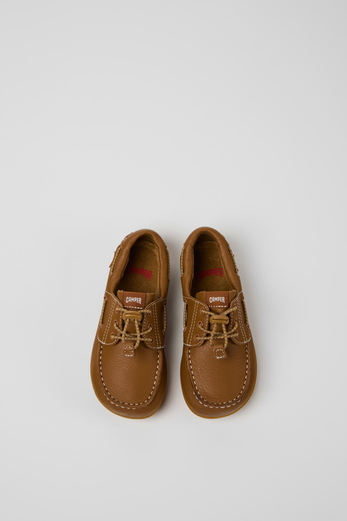 Peu Chaussures bateau en cuir marron pour enfants.