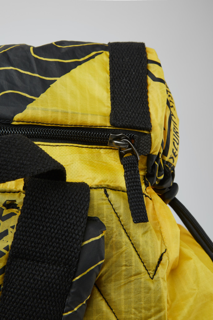 Close-up view of Camper x North Sails Yellow, black, and blue backpack
