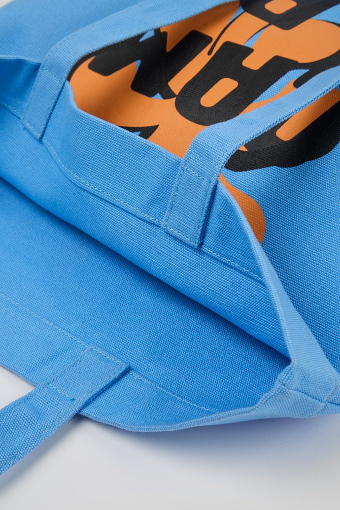 Close-up view of ConMigo Blue, orange, and black tote bag