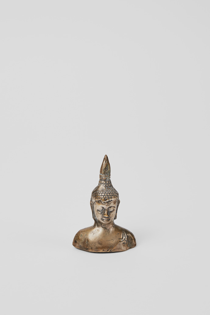 Side view of Buddha head figurine Small gray metal figurine