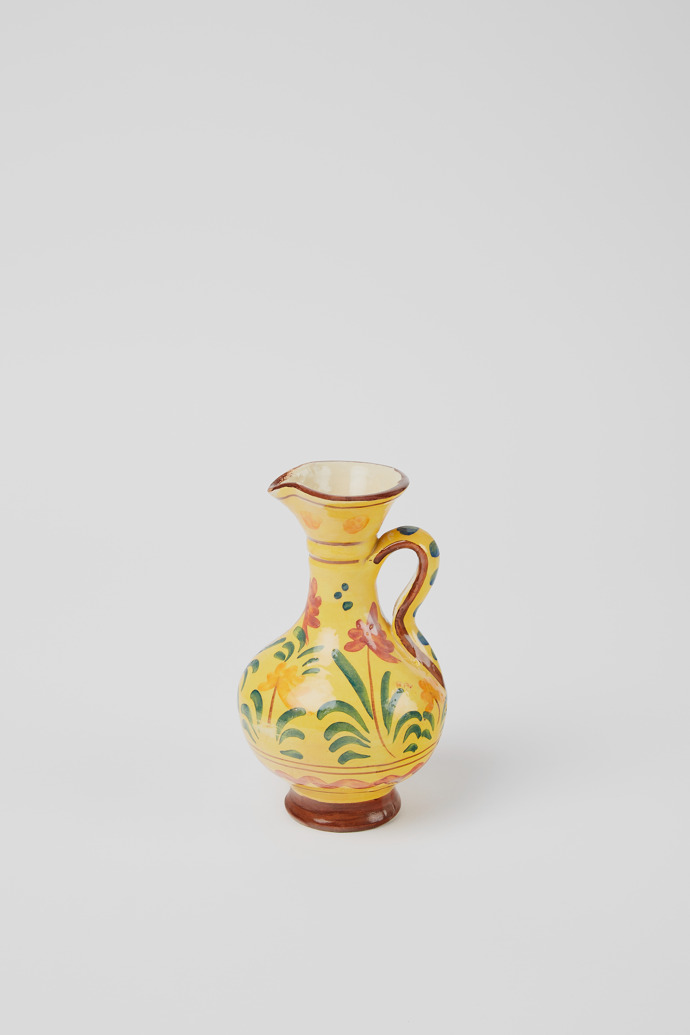 Side view of Yellow jug Yellow antique ceramic jug with floral motif