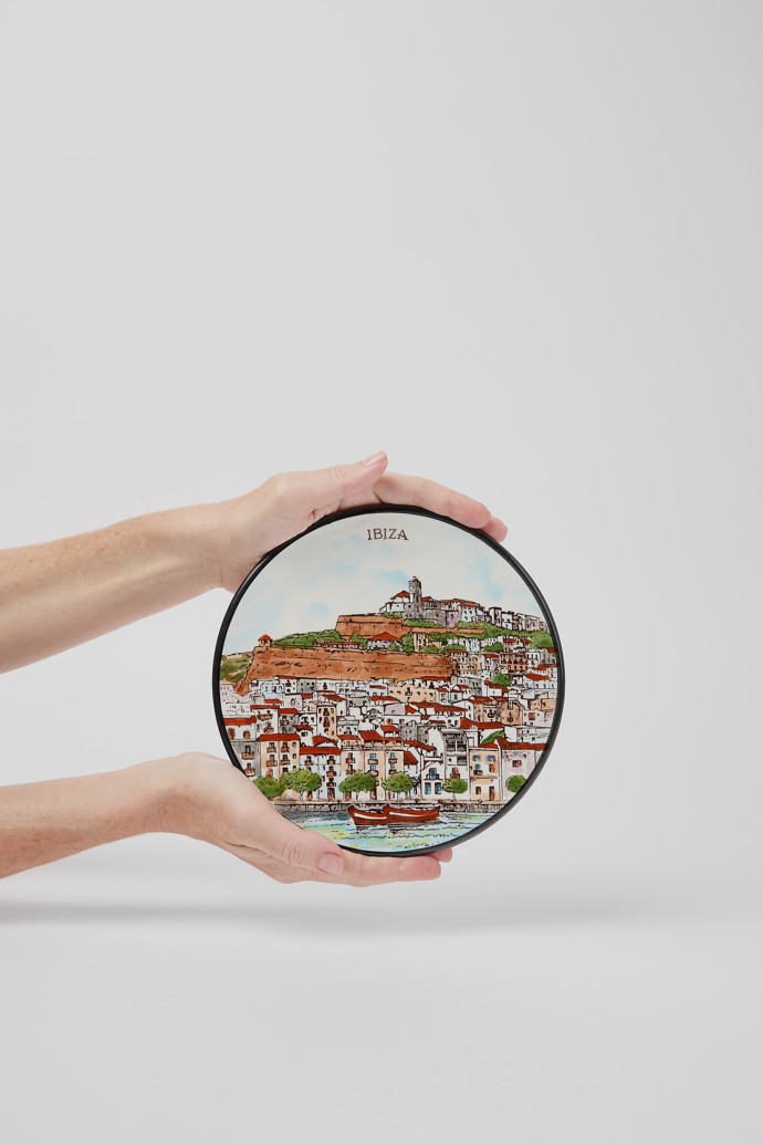 A model wearing Eivissa Town ceramic plate Ceramic plate depicting Eivissa Town