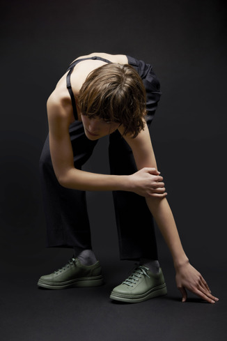 A model wearing Runner Up Green leather sneakers for women