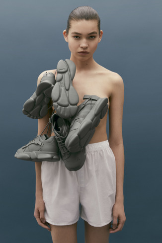 Karst Kadın için gri renkli deri ve tekstil spor ayakkabı giyen bir model