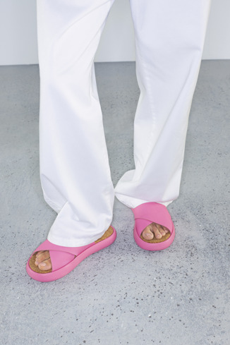 Pelotas Flota Kadın için pembe deri sandalet giyen bir model
