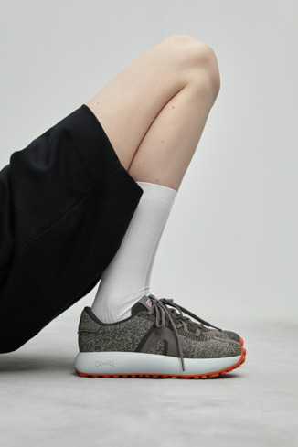 A model wearing Pelotas Athens Gray Textile Sneaker for Women