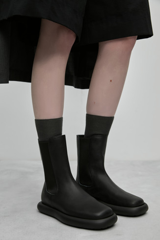 A model wearing Onda Black Leather Boots for Women