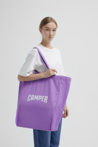 A model wearing Totes Purple Tote Unisex Shoulder Bag