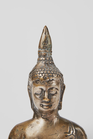 Close-up view of Buddha head figurine Small gray metal figurine